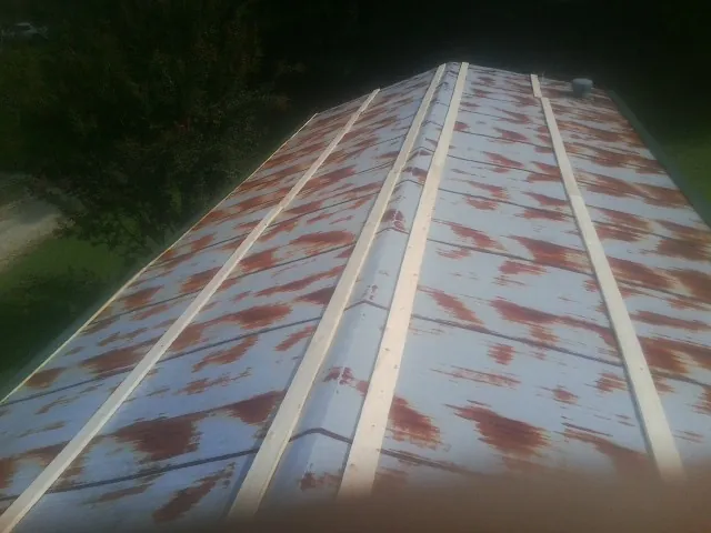 Rusted metal roof panels with new wood purlins before replacement — Storm Damage Roof Repair in Deland by Roofing Brothers
