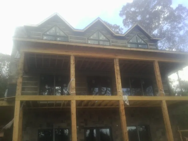 Dormers and porch framing on a large log home under construction — Roof Coating work by our crew in Deland