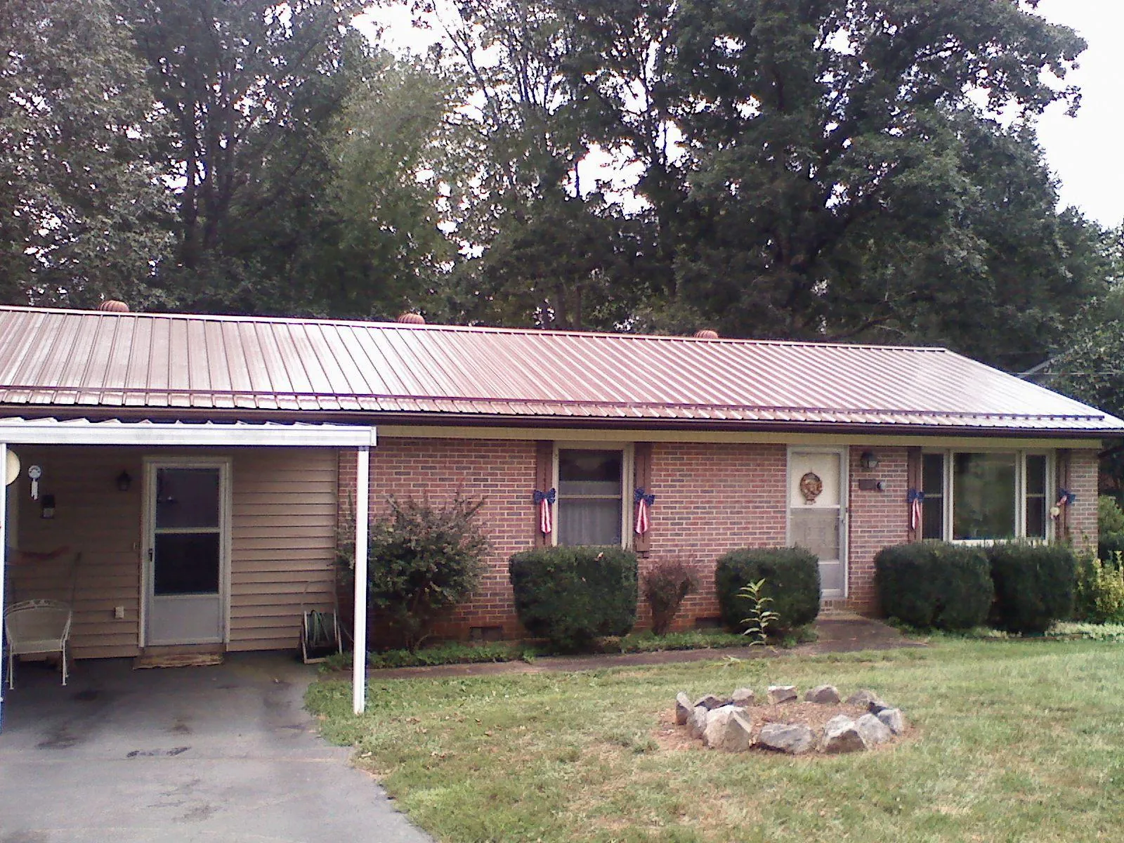 Bronze metal roof and carport on a brick ranch home — Roof Repair work by our crew in Deland